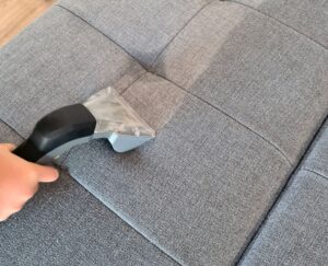Polsterdüse des Waschsaugers zieht Schmutz und Feuchtigkeit aus der Sitzfläche des Sofas