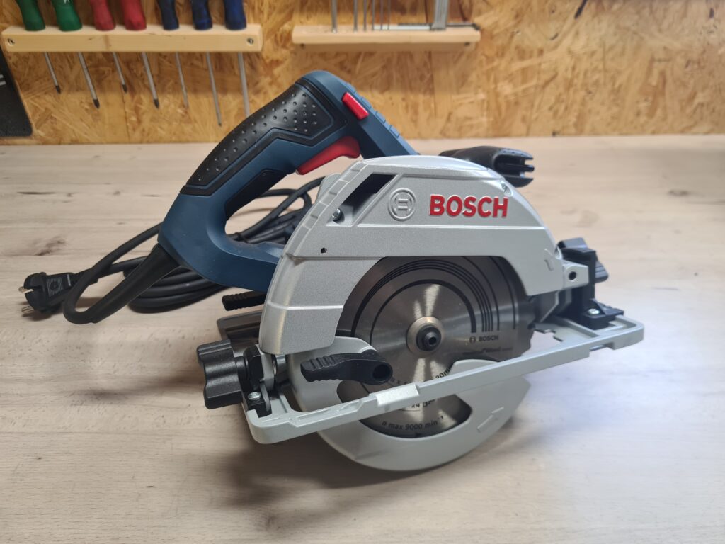 Blau-silberne Bosch Professional Handkreissäge auf einer Holzwerkbank stehend.