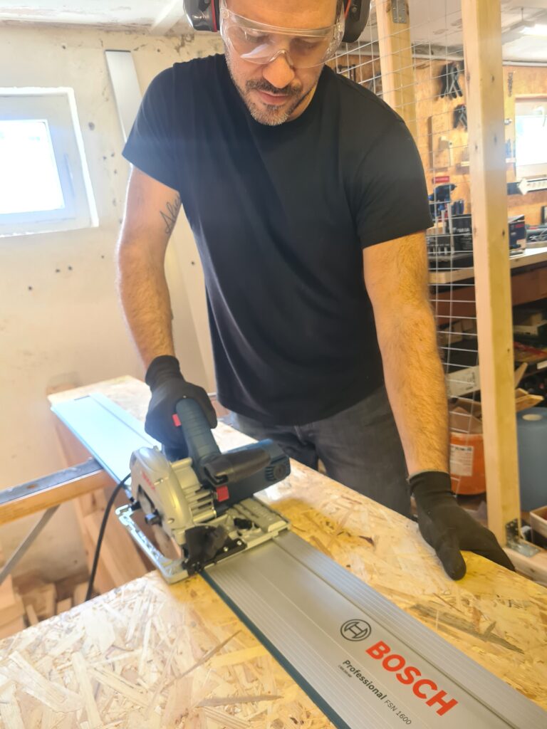 Heimwerker sägt eine OSB-Platte mit der Bosch Handkreissäge auf der FSN 1600 Führungsschiene.