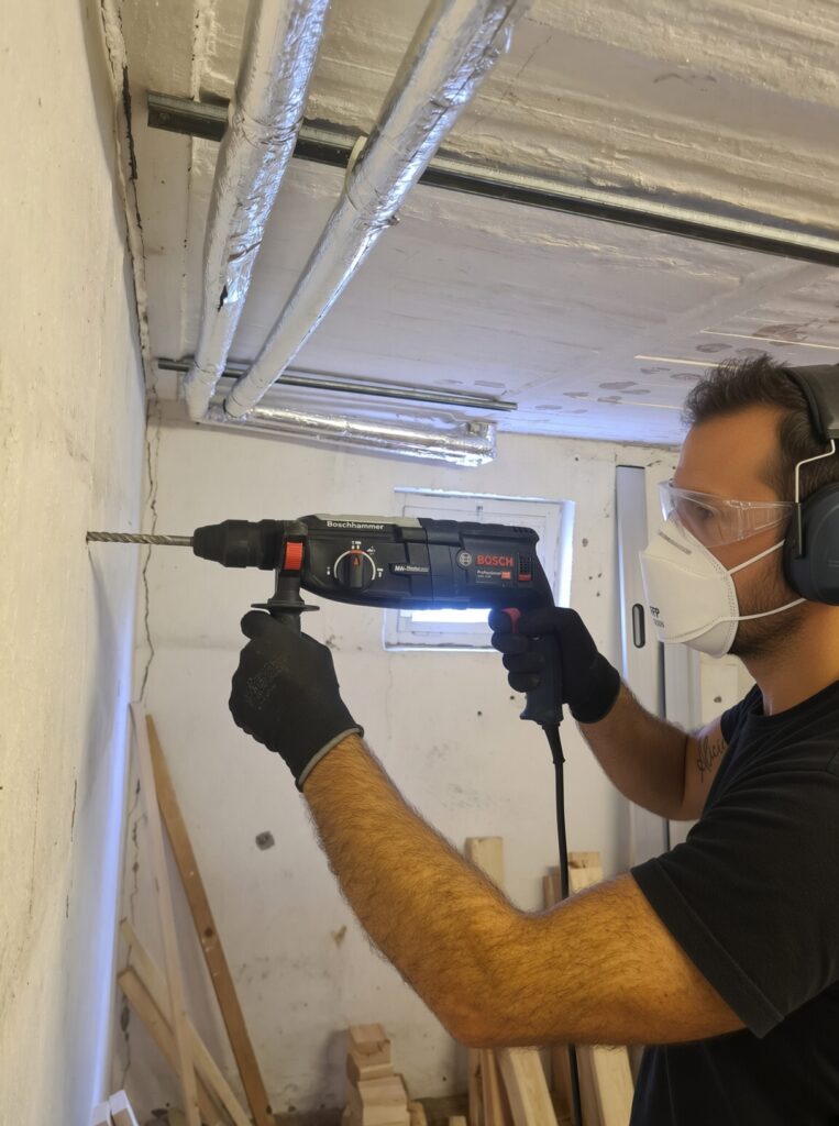 Heimwerker bohrt mit einem Bosch Professional Bohrhammer ein Loch in eine Wand
